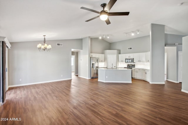 unfurnished living room with ceiling fan with notable chandelier, track lighting, high vaulted ceiling, and dark wood-type flooring