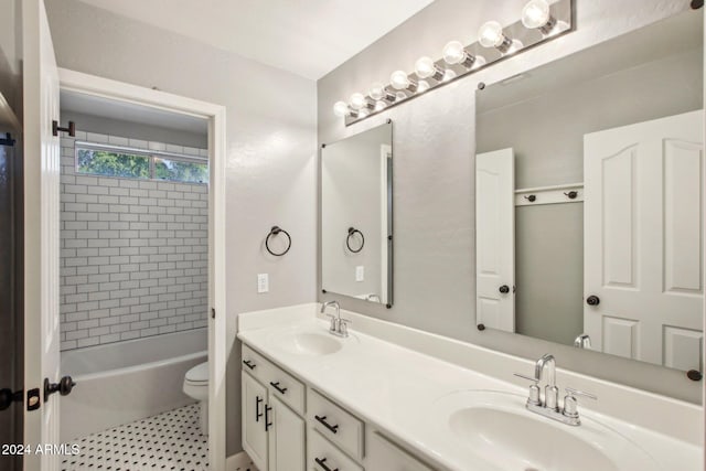 full bathroom with tiled shower / bath, vanity, and toilet