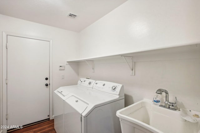 laundry area with washer and dryer, dark wood-type flooring, and sink