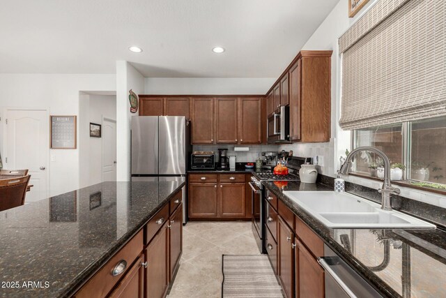 2048 S Martingale Rd, Gilbert, AZ 85295 - kitchen featuring appliances with stainless steel finishes, a sink, dark stone countertops, recessed lighting, and light tile patterned flooring