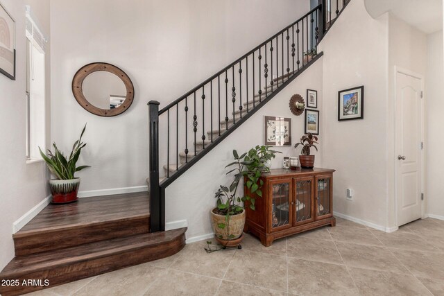 2048 S Martingale Rd, Gilbert, AZ 85295 - stairs with a towering ceiling, baseboards, and tile patterned floors
