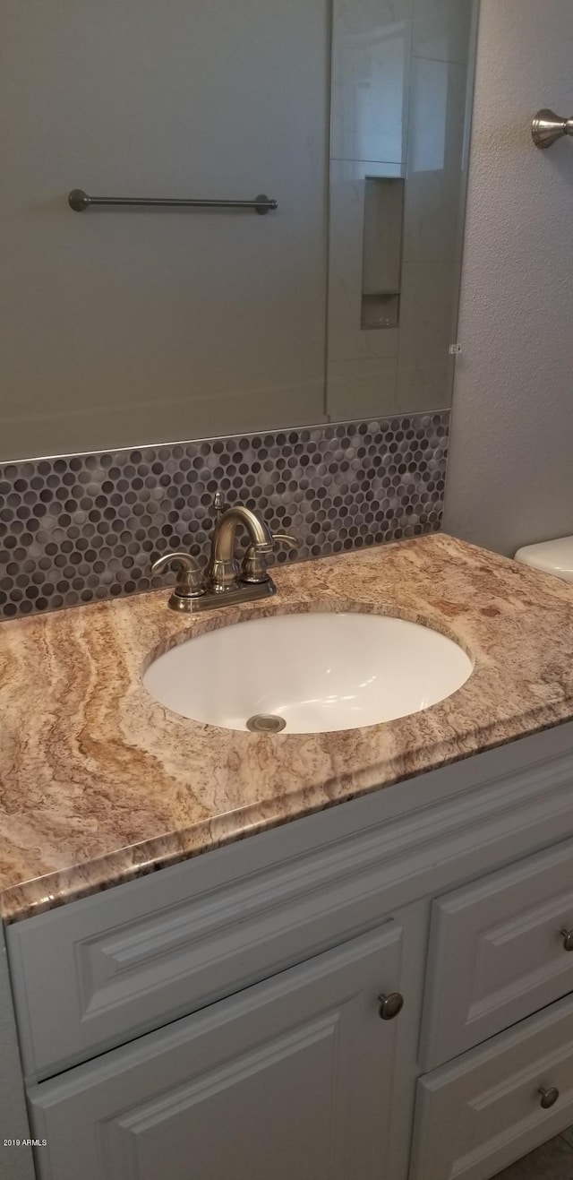 bathroom with vanity and decorative backsplash