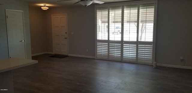 unfurnished room with ceiling fan and dark wood-type flooring