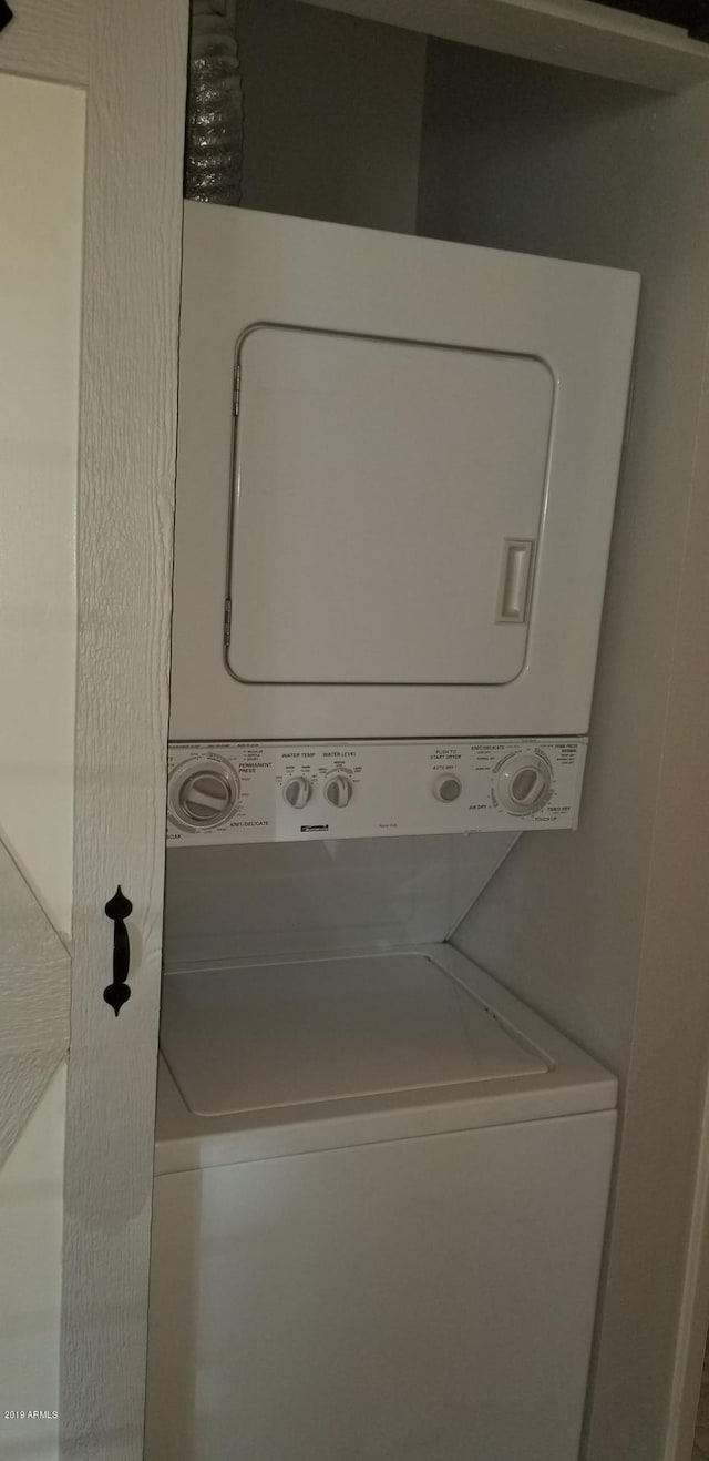 laundry area with stacked washer and clothes dryer