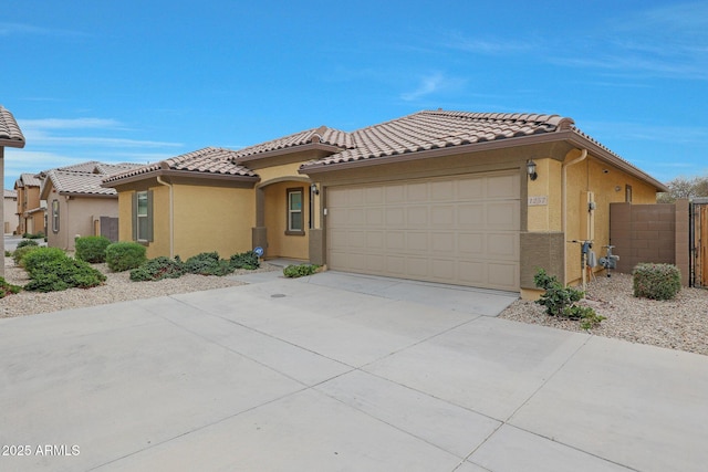 view of front of home featuring stucco siding, concrete driveway, an attached garage, fence, and a tiled roof