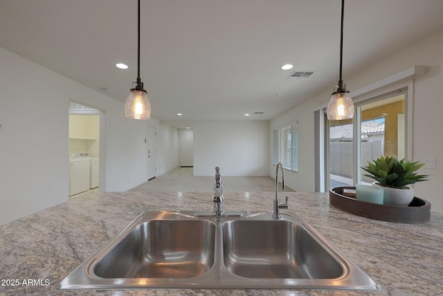 kitchen featuring recessed lighting, visible vents, a sink, and separate washer and dryer