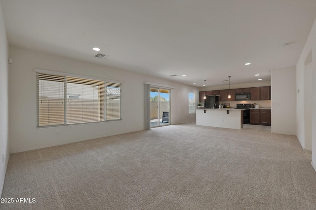 unfurnished living room with light carpet, visible vents, and recessed lighting