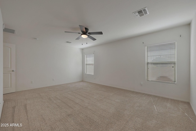 unfurnished room featuring visible vents, a ceiling fan, and light colored carpet