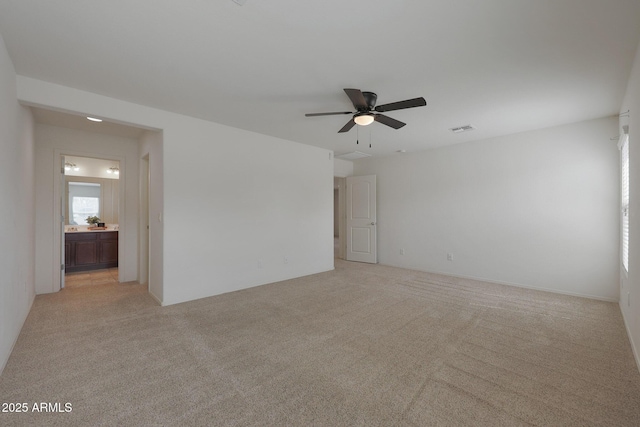 empty room with light carpet, ceiling fan, and visible vents