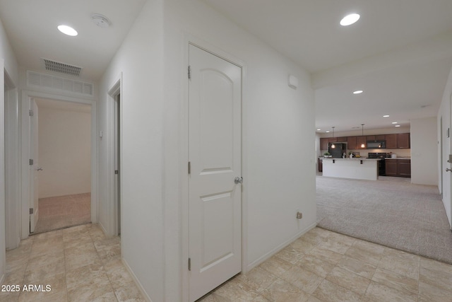 hallway featuring recessed lighting, light colored carpet, visible vents, and baseboards