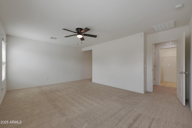 unfurnished room with a ceiling fan, visible vents, and light carpet