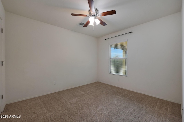 empty room with carpet floors, visible vents, and a ceiling fan