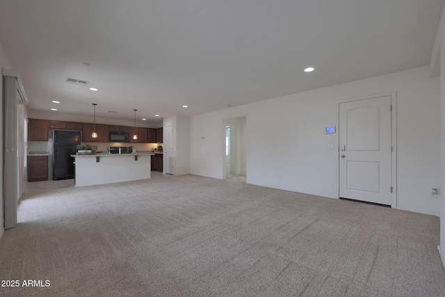 unfurnished living room featuring recessed lighting, visible vents, and light carpet