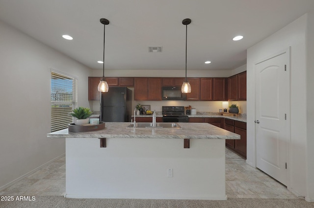 kitchen with visible vents, decorative light fixtures, black appliances, a kitchen bar, and a sink