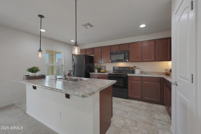 kitchen with a sink, visible vents, light countertops, black appliances, and an island with sink