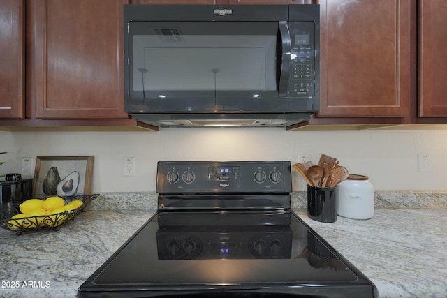 kitchen featuring black appliances and light stone counters