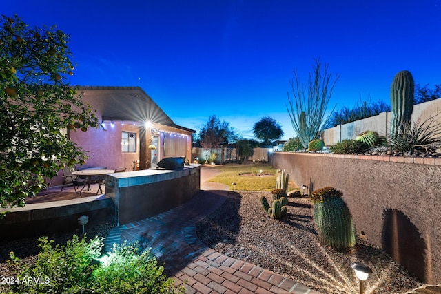 yard at dusk featuring a patio area