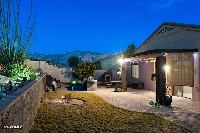 view of yard featuring a patio area, a mountain view, and a fireplace