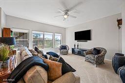 living room with a ceiling fan and carpet flooring