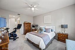 bedroom featuring a ceiling fan and light colored carpet