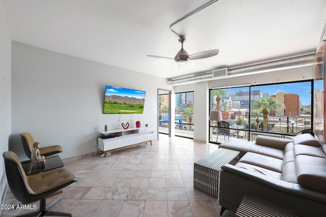 living area featuring visible vents, baseboards, and a ceiling fan