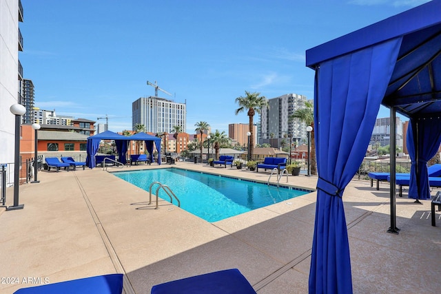 community pool featuring a gazebo, a patio area, and a view of city