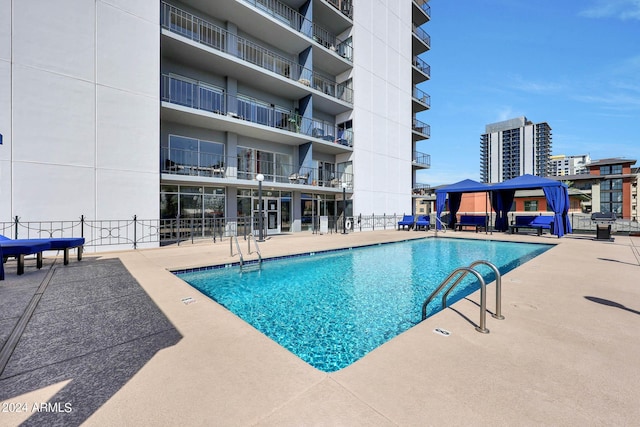 pool featuring fence and a patio