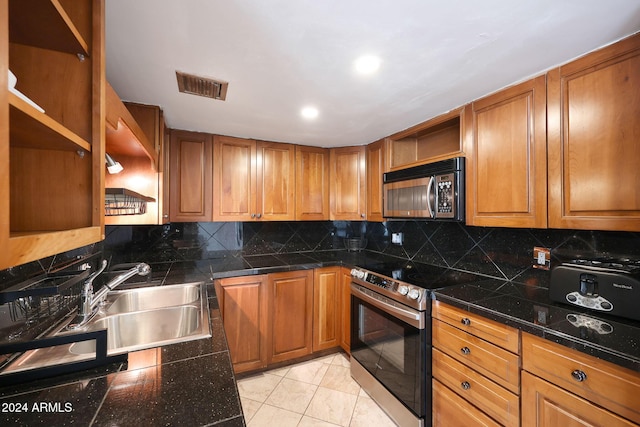 kitchen with backsplash, open shelves, visible vents, appliances with stainless steel finishes, and a sink