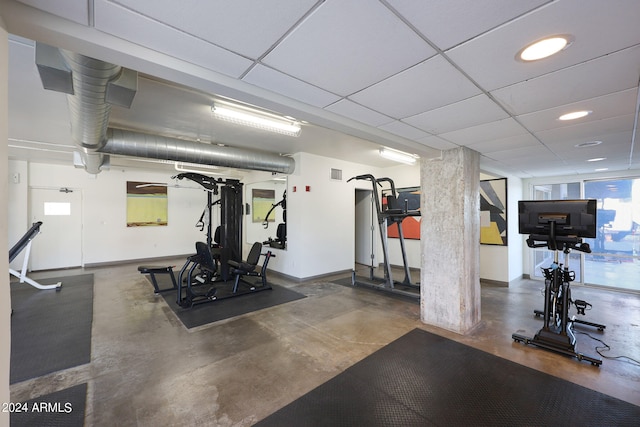 gym with concrete flooring and a drop ceiling