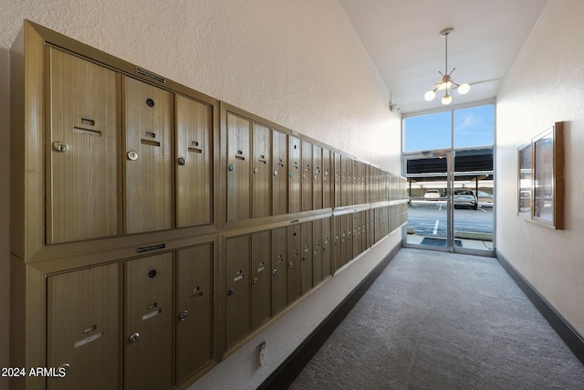 corridor with mail area and an inviting chandelier