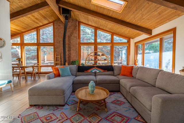 living room featuring light wood-type flooring, a skylight, wood ceiling, beam ceiling, and high vaulted ceiling