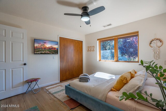 bedroom featuring ceiling fan, light hardwood / wood-style floors, and a closet