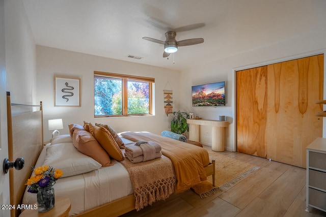 bedroom featuring ceiling fan, light hardwood / wood-style floors, and a closet