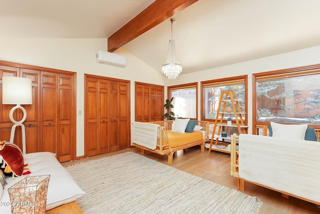 bedroom featuring a wall mounted air conditioner, lofted ceiling with beams, light hardwood / wood-style flooring, a notable chandelier, and multiple closets