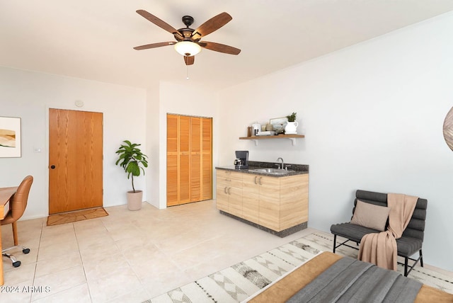 living area featuring ceiling fan, sink, and light tile patterned floors