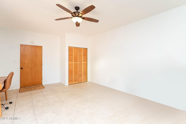 unfurnished room with ceiling fan and light tile patterned flooring