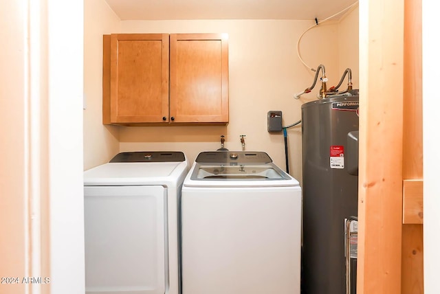 clothes washing area featuring cabinets, electric water heater, and washing machine and dryer