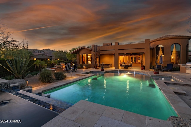 pool at dusk with a patio