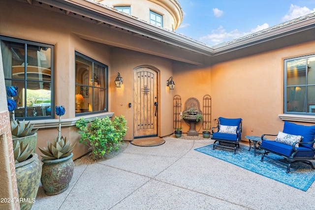 view of exterior entry with a patio area