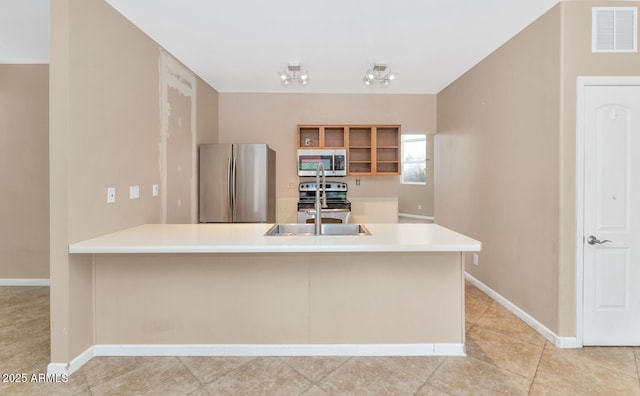 kitchen featuring appliances with stainless steel finishes, sink, light tile patterned floors, and kitchen peninsula