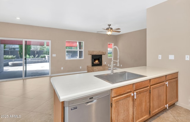 kitchen featuring dishwasher, sink, a fireplace, and kitchen peninsula