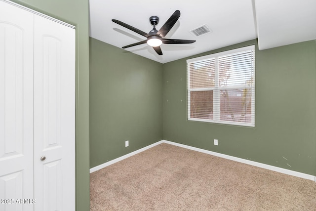 carpeted spare room featuring ceiling fan