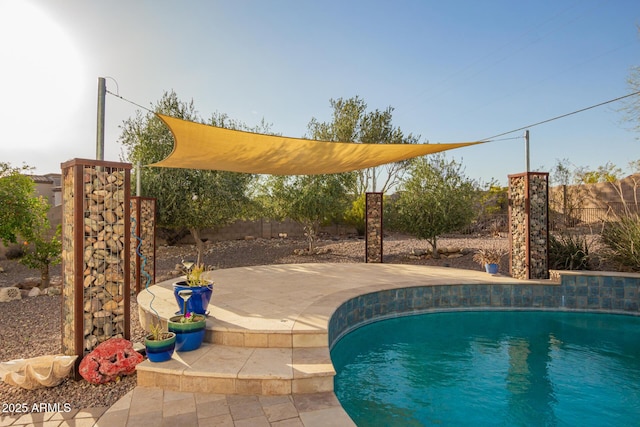 outdoor pool with a patio area and a fenced backyard