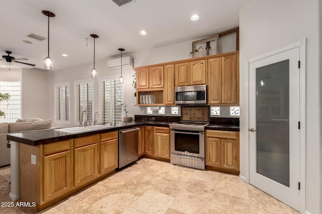 kitchen with visible vents, appliances with stainless steel finishes, a wall mounted air conditioner, a peninsula, and a sink