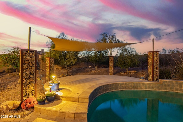 outdoor pool with a patio and a fenced backyard