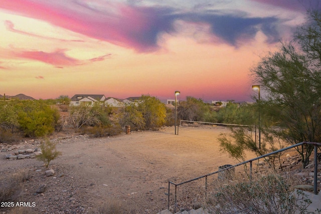 yard at dusk with volleyball court and fence