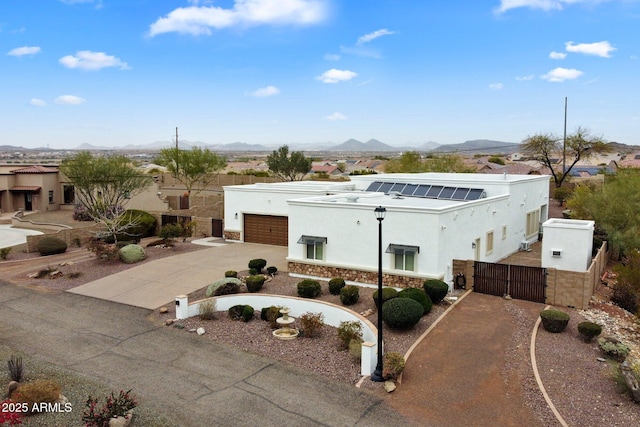 view of front of home with a garage, a mountain view, a gate, and stucco siding