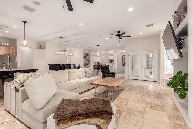 living area with visible vents, arched walkways, a ceiling fan, and recessed lighting