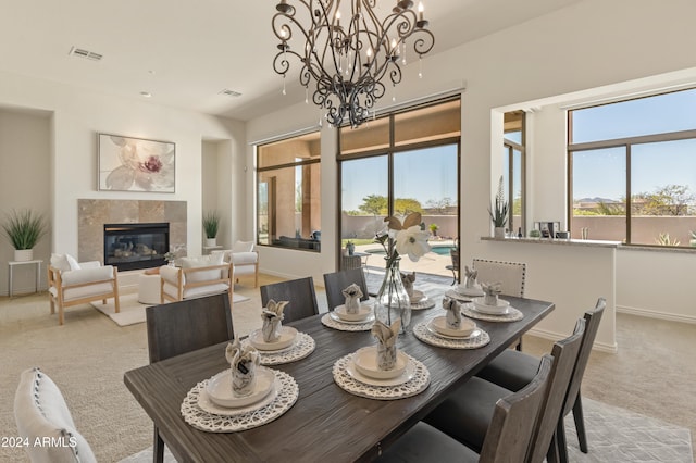 carpeted dining room with an inviting chandelier and a fireplace