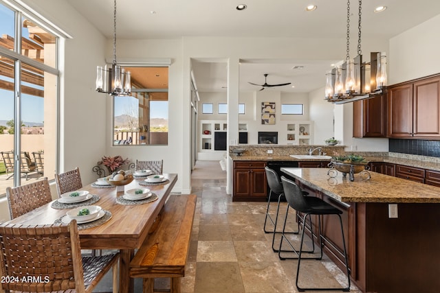 kitchen featuring kitchen peninsula, decorative light fixtures, a breakfast bar, and ceiling fan